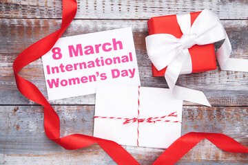 Fototapeta na wymiar Card with text 8 March International Women's Day, envelope with letter, gift and red ribbon on wooden background