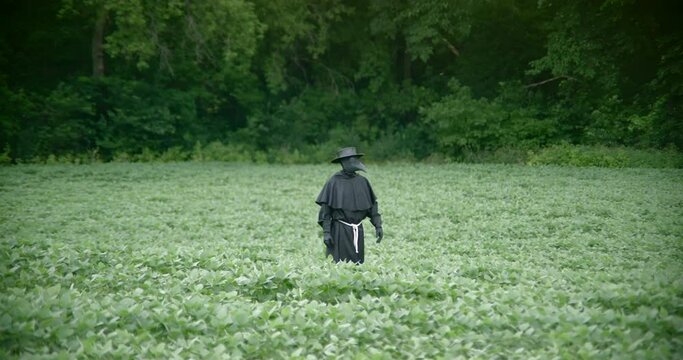 Plague doctor in field with slow motion zoom in