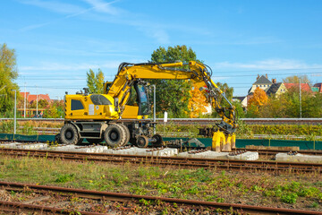 a Road-Rail Excavator on Train wheels at the construction site of rail tracks for lifting Concrete sleepers or concrete ties