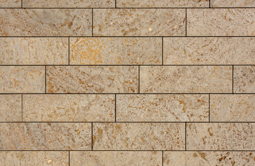 texture of a tiled beige stone wall as background