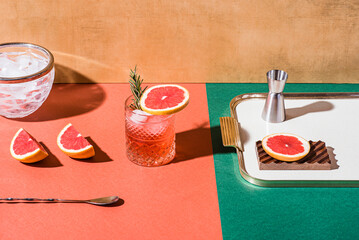 Red cocktail in base of Campari or bitter with blood red oranges (tarocco) on the geometric  background. Aperitif with Americano or Negroni cocktail. Retro chic style