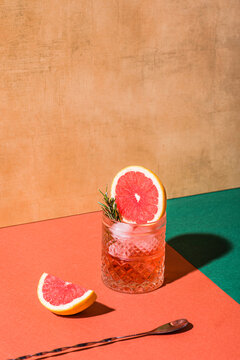 Red cocktail in base of Campari or bitter with blood red oranges (tarocco) on the geometric  background. Aperitif with Americano or Negroni cocktail. Retro chic style, vintage props
