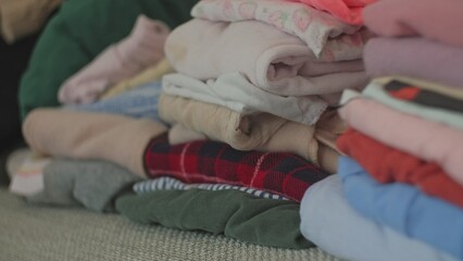 Obraz na płótnie Canvas Stacks of Colorful Folded Laundry Second Hand Clothes Prepared for Bulk Sale Online