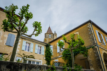 Fototapeta na wymiar The quaint facades and bell tower of the church of Lavardens, in the south of France (Gers)