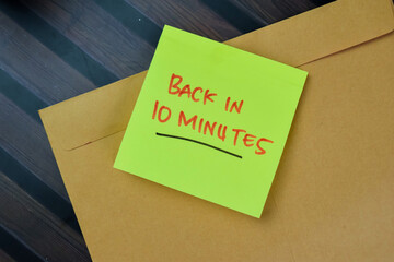 Concept of Back in 10 Minutes write on sticky notes isolated on Wooden Table.