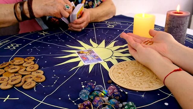 A fortune teller reads with tarot cards. Selective focus.