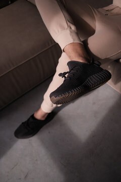 guy is sitting on the sofa. Fashion wallpaper. Hype sneaker.