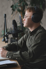 man in studio is recording podcast, audio content of interview on radio. Caucasian male speaks into microphone for voice recording or advertising. working online on internet, discussing acutely social