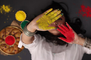 A beautiful woman girl lady laying down posing for holi celebration with Abeer gulal dry color...