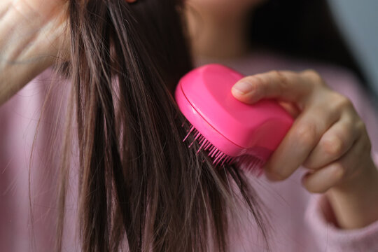 closeup female holding messy unbrushed dry hair in Hands. Hair damage concept.