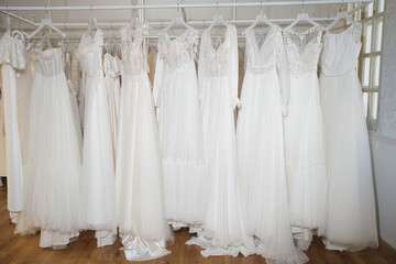 Fototapeta na wymiar Different wedding dresses on hangers in boutique