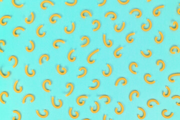 Top view of thin, twisted smooth and tube shaped 'Gramigna' pasta on blue background