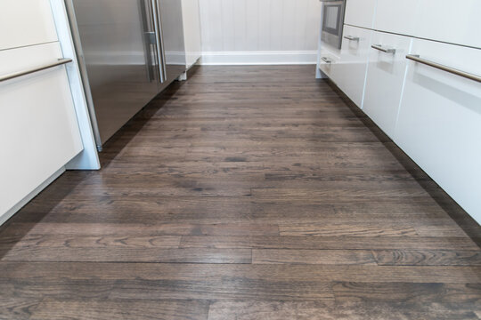 Dark wood hardwood floors in a newly renovated white cabinet modern kitchen