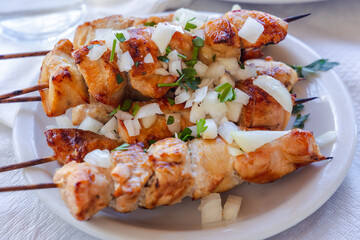 Greek Chicken Souvlaki shashliks with onion on a plate Cyprus island country