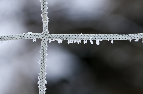 details of icicles on a rope-fence - cross dividing the image