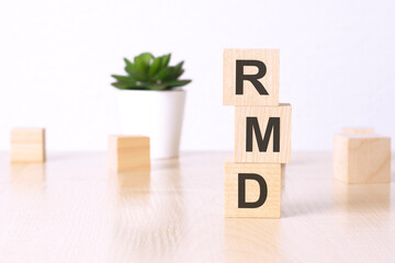 RMD - Required Minimum Distribution - text on wooden cubes on a white background