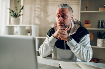 Middle aged man using a laptop while working in a home office