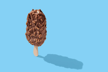 Chocolate ice cream on a stick blue pastel background