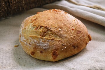 bread on the tablecloth. Home baked whole grain bread. Crusty sourdough loaf of wheat bread with wholegrain flour. fried bread crust. 