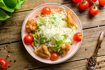 Salad caesar with chicken on white plate top view