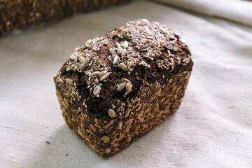 freshly baked grain bread. bread on the tablecloth. Home baked whole grain bread. Crusty sourdough loaf of wheat bread with wholegrain flour.