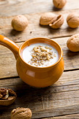 matsoni with honey and nuts on old wooden table