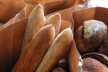 freshly baked bread in craft bags. Home baked whole grain bread. Crusty sourdough loaf of wheat bread with wholegrain flour. 
