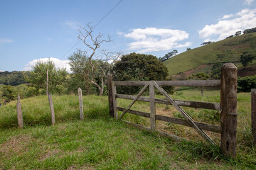 Farm gate with trees and grass on background. Countryside of Sao Paulo state, Brazil