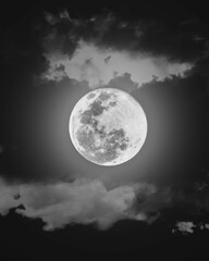 Fototapeta na wymiar Luna llena con resplandor alrededor de unas nubes