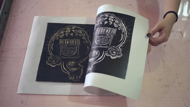 Crop unrecognizable woman lino printing in traditional technique workshop creating artwork with brayer