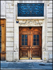 The wooden door of an old building in the 13th arrondissement of Paris, France
