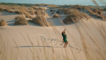 Girl graceful dance sand desert summer windy evening. Woman performing at dunes.