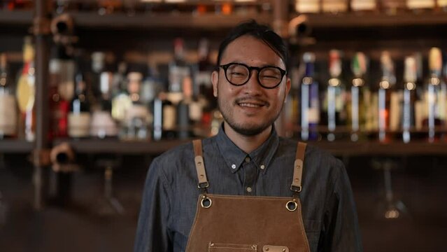 Night club concept of 4k Resolution. Asian bartender smiling with confidence in store. A group of specialized clubs that sell alcoholic beverages.