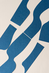elegant blue paper shapes arranged on light beige paper