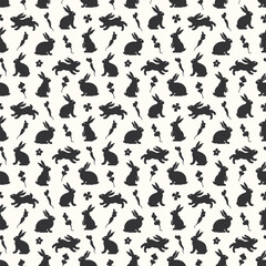 Fototapeta na wymiar Hand drawn seamless pattern with cute doodle silhouette bunnies. Easter background. Perfect for textile or paper wrapping design. Vector illustration