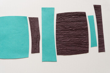 Naklejka premium blue and brown paper stripes and squares on blank paper