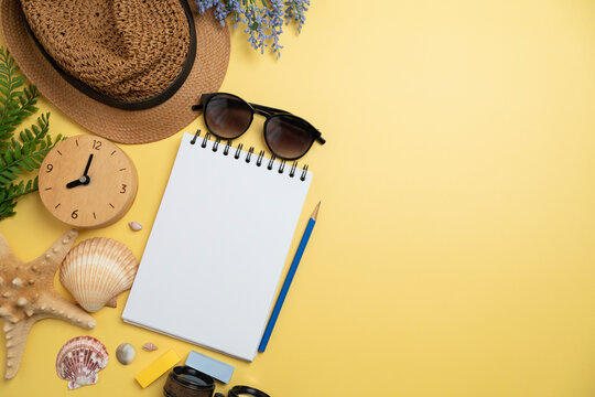 Flat lay concept of travel accessories vacation trip and long summer weekend planning on yellow table with blank space for text background.
