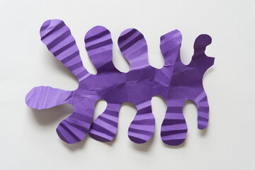 cut and folded purple paper shape in the form of polyps, columnar, finger, fringe, or organics on...