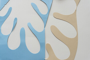 blue and beige paper shapes in the form of polyps, columnar, finger, fringe, or organics on blank...