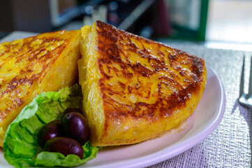Spanish vegetarian food, portion of homemade tasty potato omelette tortilla de patatas with onion served in morning sunlights