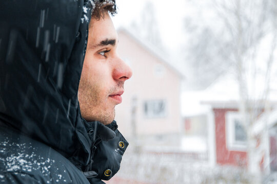 Young man watching the snow fall