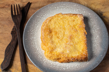 (Torrijas) Fried bread soaked in milk flavored with vanilla, cinnamon, lemon and egg on a wooden background.Typical Easter sweet. Concept of traditional festive cuisine.