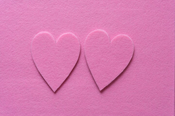 Fototapeta premium two piles of pink felt hearts on pink felt ground