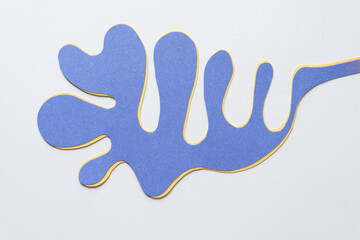 mostly blue and some yellow cut paper shape (polyp, columnar, organic, or finger) on blank paper