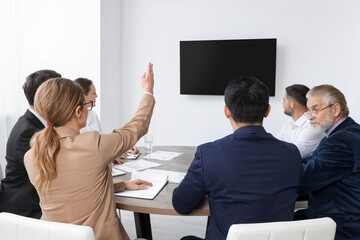 Business conference. Group of people watching presentation on tv screen in meeting room