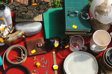 Many different items on table outdoors, above view. Garage sale