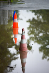 Traffic cones in the water, close up.