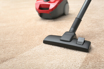 Vacuuming dirty beige carpet. Clean area after using device, closeup