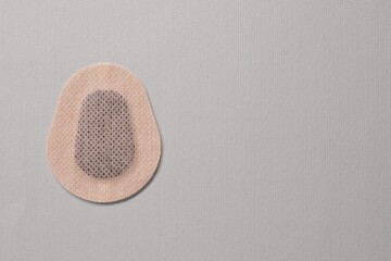 Contraceptive patch on light grey background, top view. Space for text