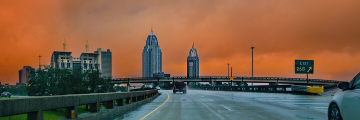 Mobile Alabama downtown skyline in winter rain at dusk, roadtrip cityscape with historical landmark buildings seen from Interstate 10 Highway